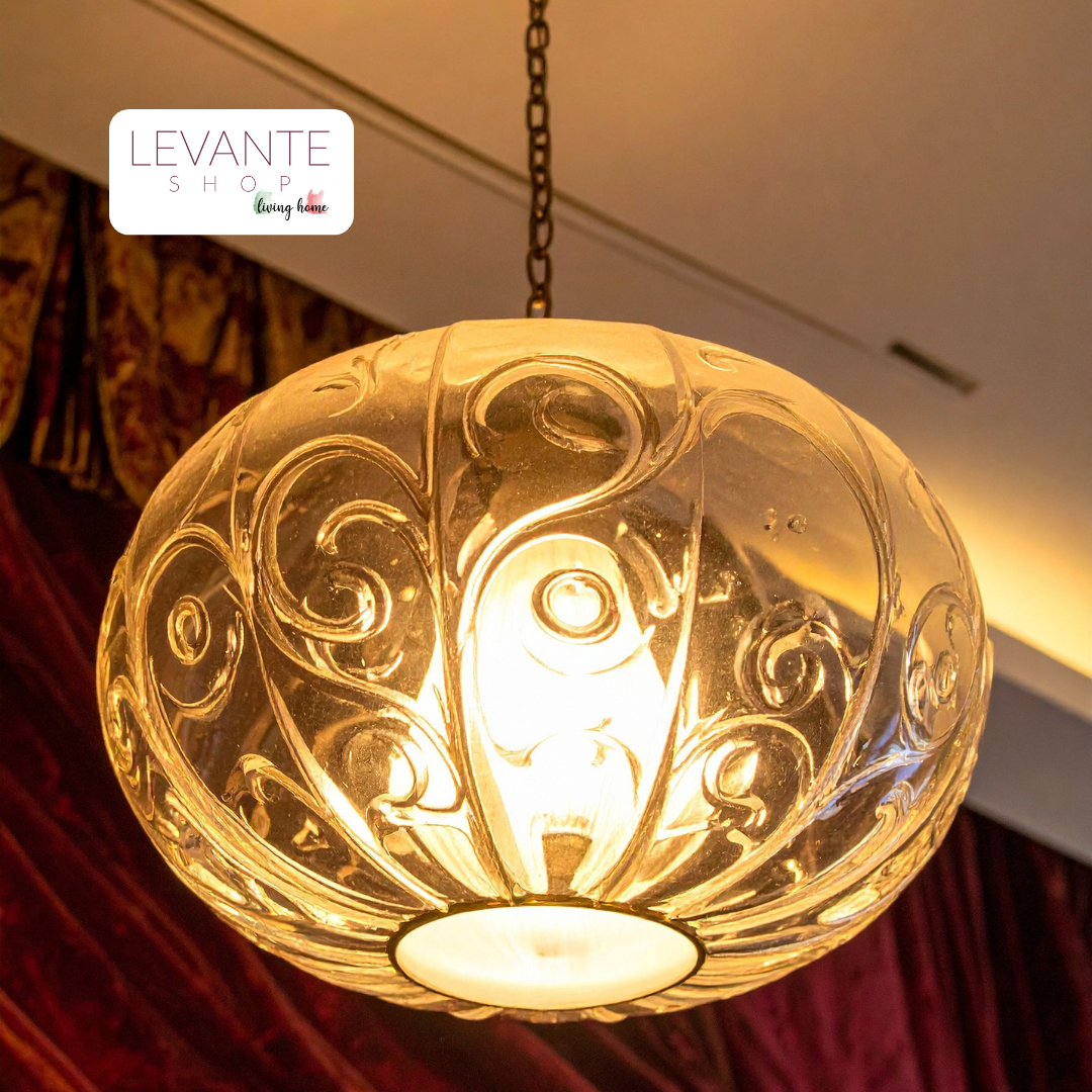 Lampadario a sospensione in vetro decorato acceso con luce calda, perfetto per soggiorno o zona pranzo
